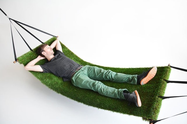 A man lying on an artificial grass hammock